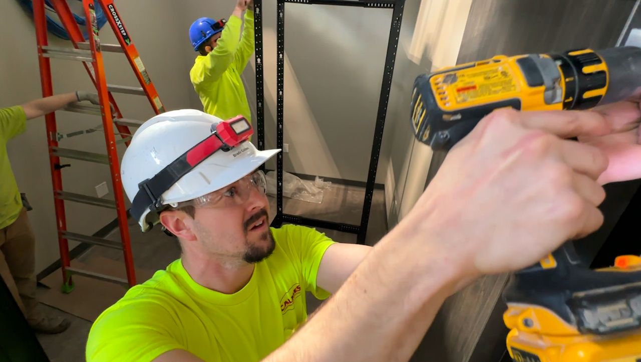 Brady Calmes hangs a door in an office under constriction in Wrightstown, Wisconsin.