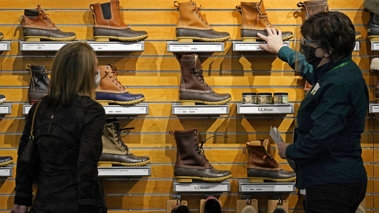 A salesperson helps a customer shopping for Bean Boots at the L.L. Bean flagship retail store in Freeport, Maine. (AP Photo/Robert F. Bukaty, File)