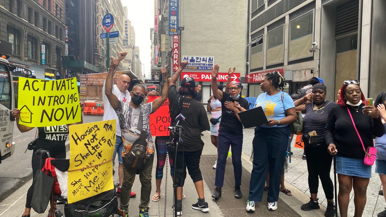 Residents gathered near Hotel at Fifth Avenue holding signs during press conference.