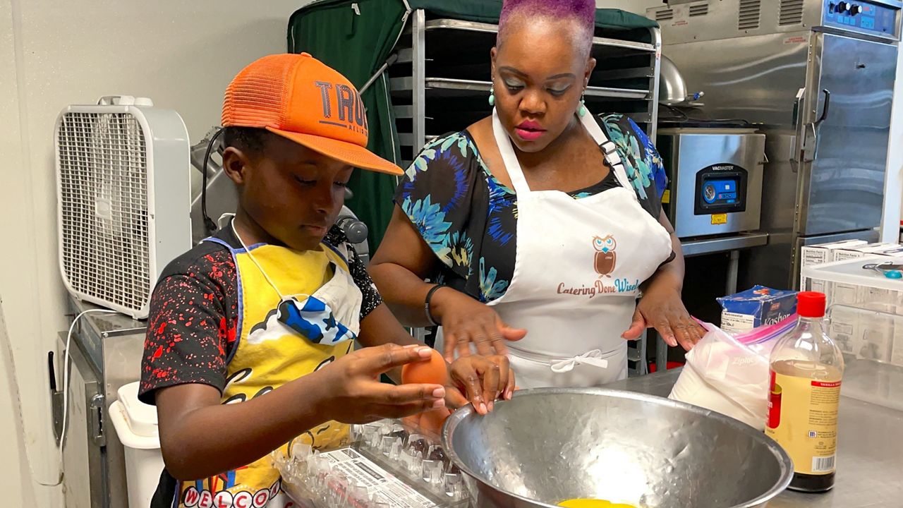 Shanay and Dallas cracking eggs for cookie batter (Spectrum News 1)