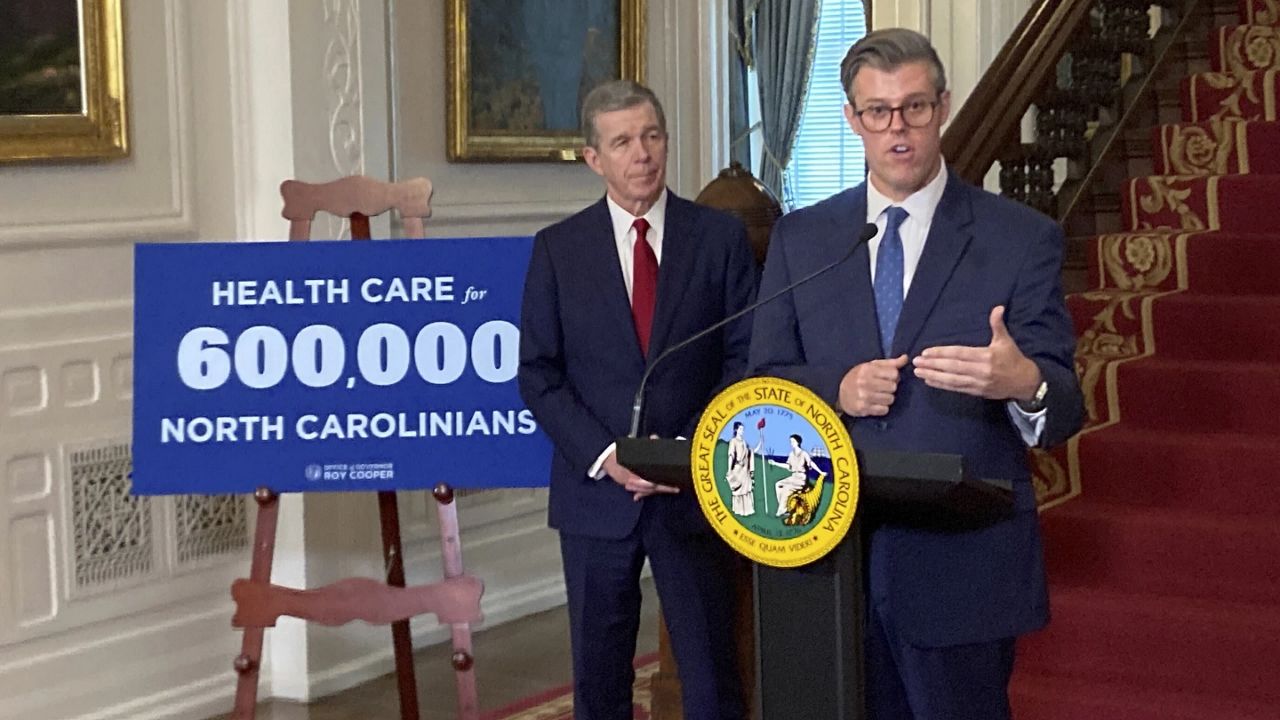 North Carolina Health and Human Services Secretary Kody Kinsley, right, speaks while Gov. Roy Cooper listens at an Executive Mansion news conference in Raleigh, N.C., on Monday, Sept. 25, 2023. Kinsley and Cooper announced that North Carolina would launch Medicaid expansion coverage on Dec. 1. Expansion will be able to start because Cooper said he'll let a state budget bill sent by the General Assembly last week to his desk become law without his signature. (AP Photo/Gary D. Robertson)