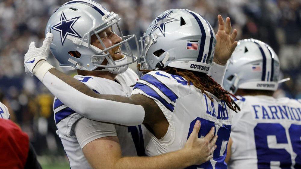 Dallas Cowboys quarterback Cooper Rush, left, and wide receiver CeeDee Lamb (88) celebrate after Rush threw a touchdown pass to Lamb in the second half of a NFL football game against the Washington Commanders in Arlington, Texas, Sunday, Oct. 2, 2022. (AP Photo/Ron Jenkins)