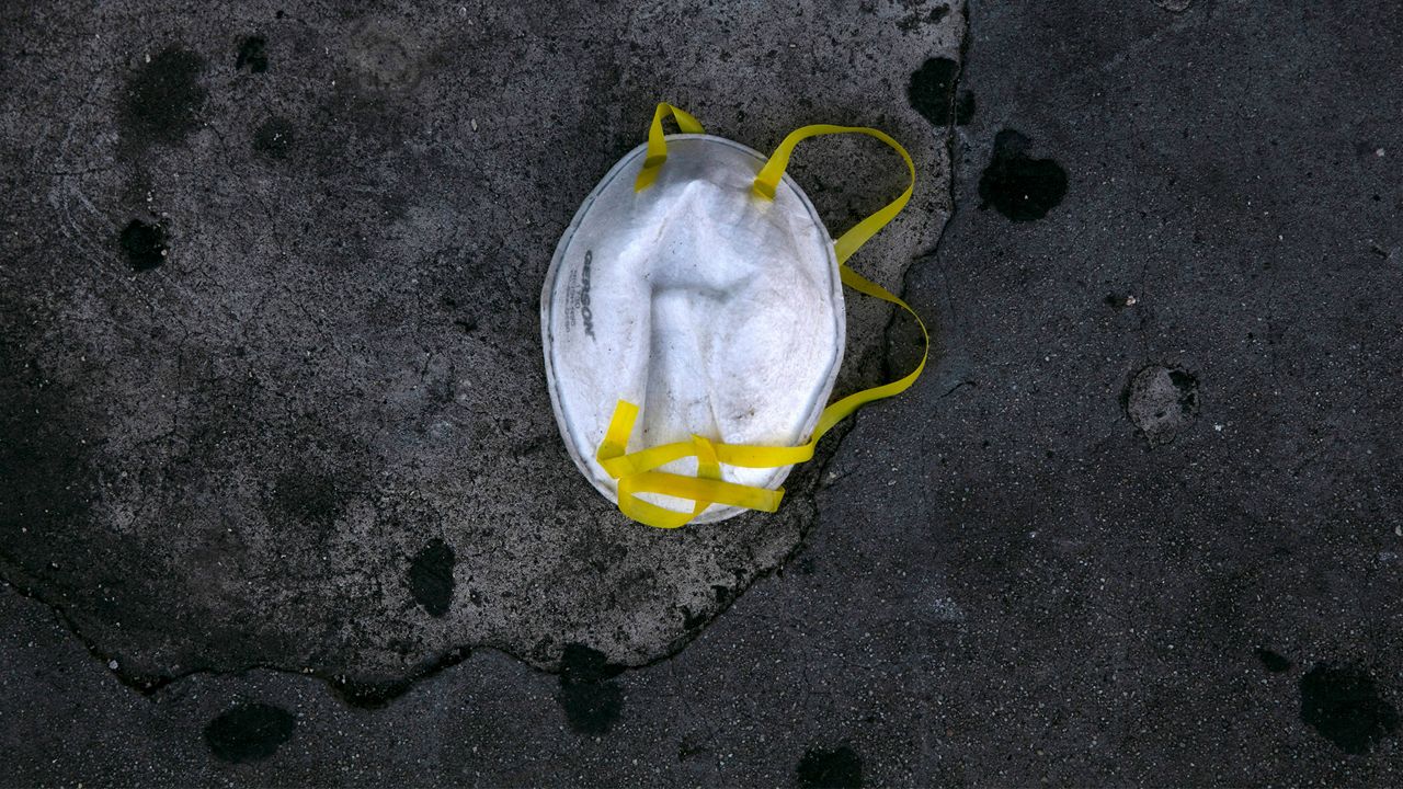 A face mask is discarded on a sidewalk during the coronavirus outbreak in the Westlake neighborhood of Los Angeles, Thursday, May 21, 2020. While most of California took another step forward to partly reopen in time for Memorial Day weekend, Los Angeles County didn't join the party because the number of coronavirus cases has grown at a pace that leaves it unable to meet even the new, relaxed state standards for allowing additional businesses and recreational activities. (AP Photo/Jae C. Hong)