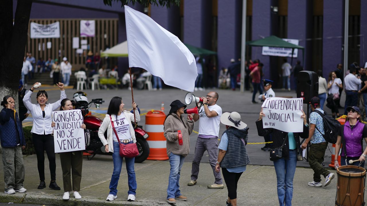 Unionized federal court workers hold signs and shout slogans as they strike over reforms that would make all judges stand for election, outside a federal court in Mexico City, Wednesday, Aug. 21, 2024. (AP Photo/Eduardo Verdugo)