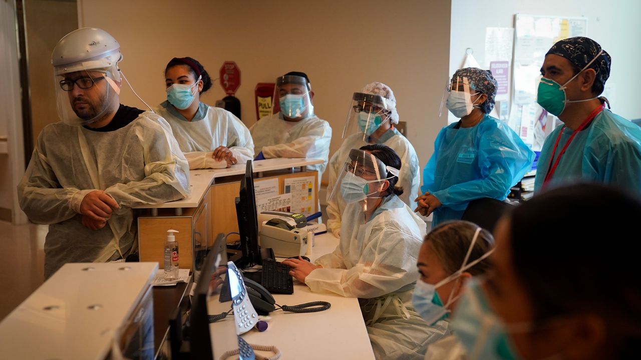 Nurses gather for a meeting in a COVID-19 unit at Providence Holy Cross Medical Center in the Mission Hills section of Los Angeles, Tuesday, Dec. 22, 2020. (AP Photo/Jae C. Hong)