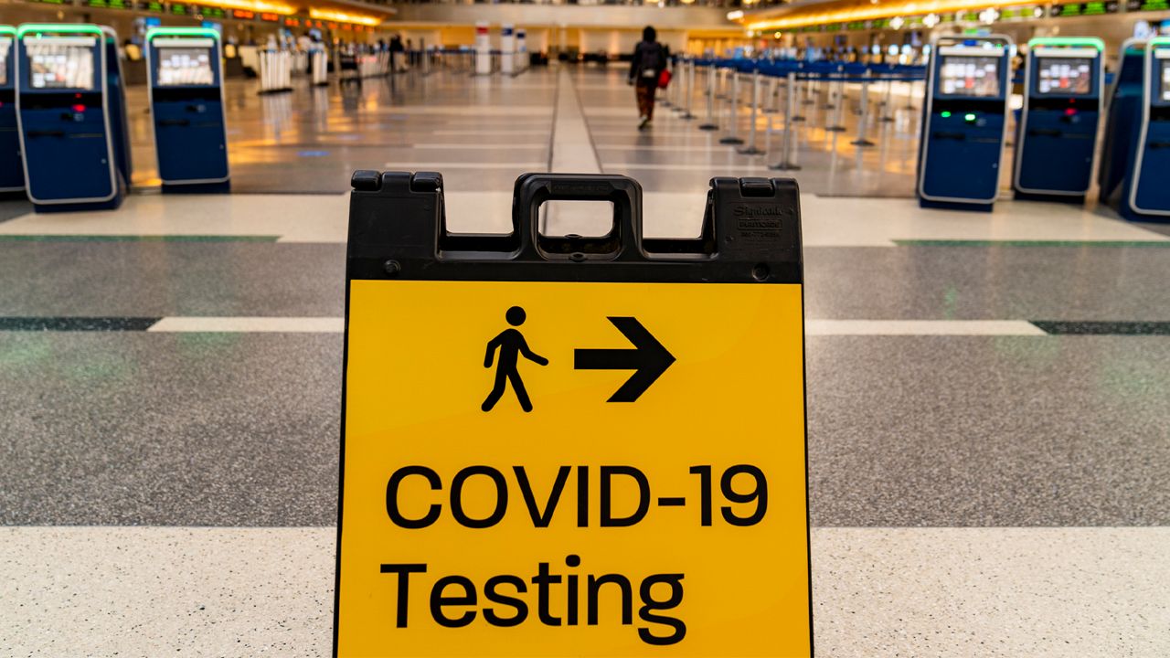 A COVID-19 testing sign is posted at the empty Tom Bradley International Terminal at Los Angeles International Airport Wednesday, Nov. 25, 2020.  (AP Photo/Damian Dovarganes)