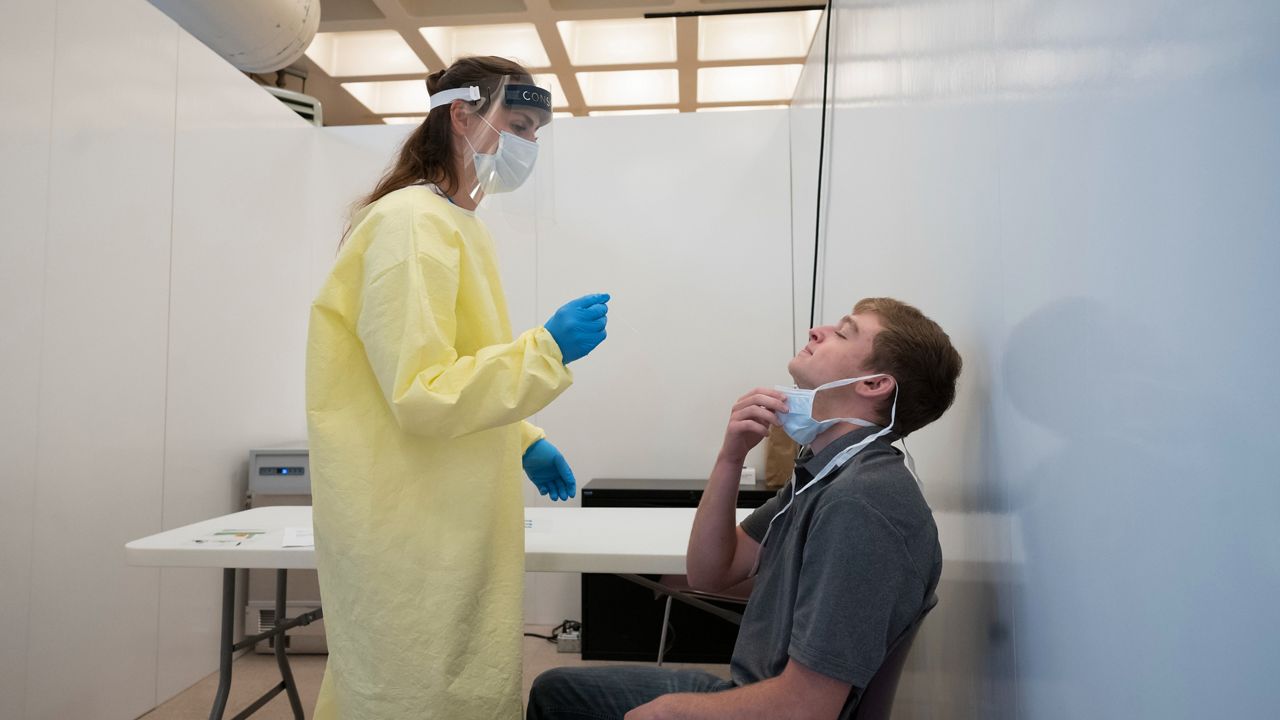 Woman gives man a COVID-19 test