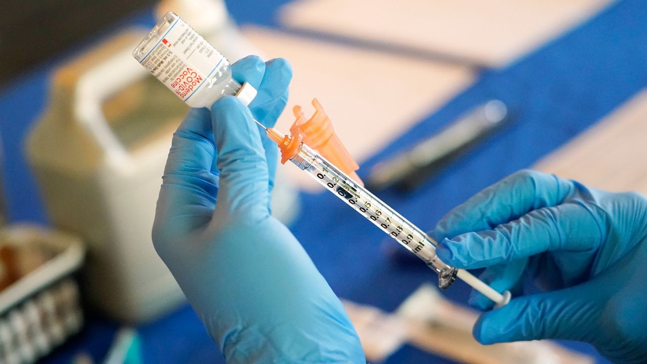 A nurse prepares a syringe of a COVID-19 vaccine at an inoculation station on Tuesday, July 19, 2022.
