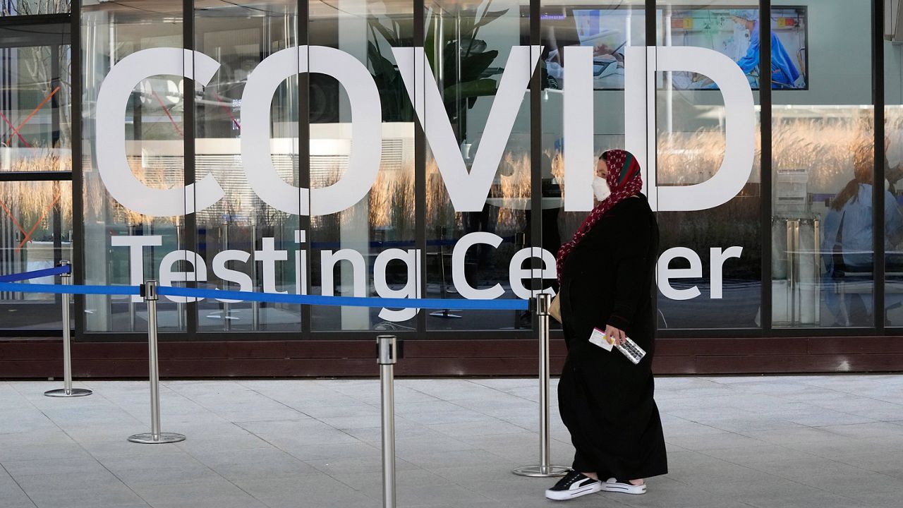 A woman stands outside a COVID-19 testing center. (Associated Press)