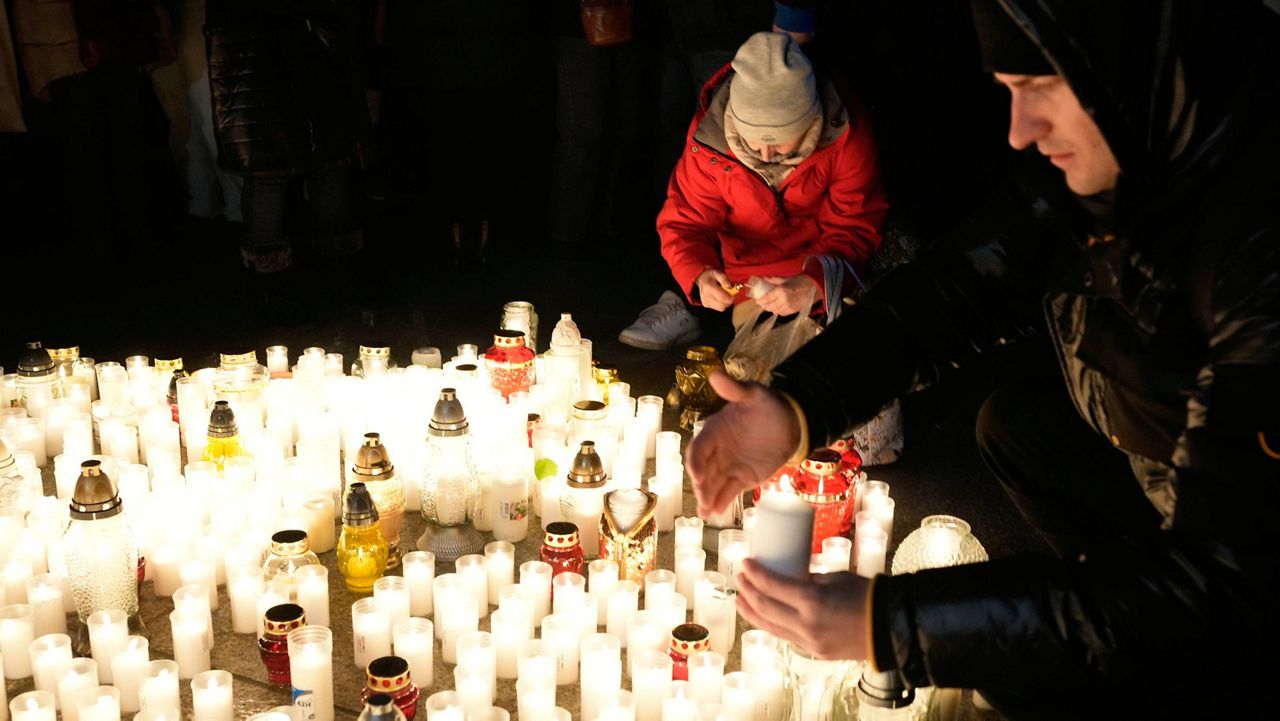 People light candles in Warsaw, Poland, on Jan. 11 to commemorate those who who have died from COVID-19. (AP Photo/Czarek Sokolowski)