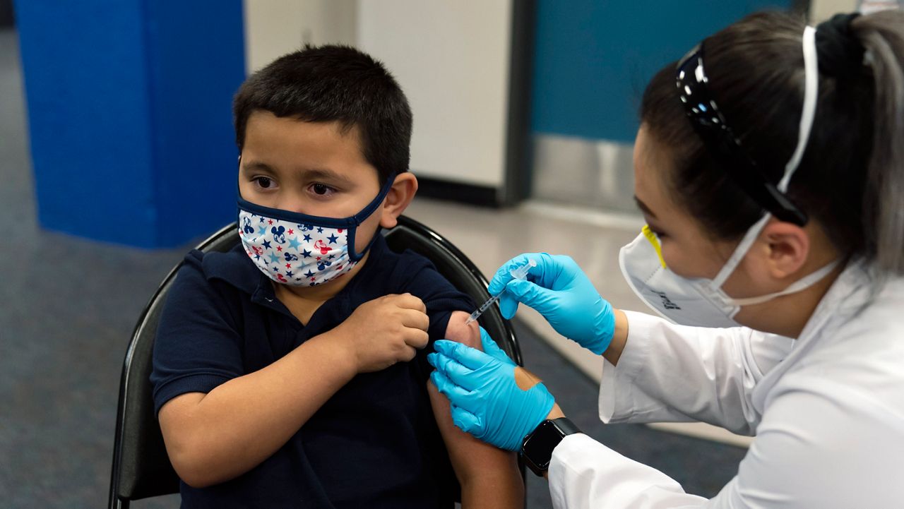 Six-year-old Eric Aviles receives the Pfizer COVID-19 vaccine from pharmacist Sylvia Uong at a pediatric vaccine clinic for children ages 5 to 11 set up at Willard Intermediate School in Santa Ana, Calif., Tuesday, Nov. 9, 2021. (AP Photo/Jae C. Hong)