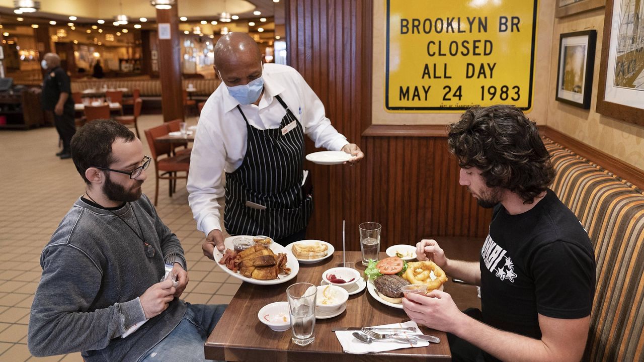 A waiter serves lunch at Junior's restaurant in New York. (AP Photo/Mark Lennihan, File)