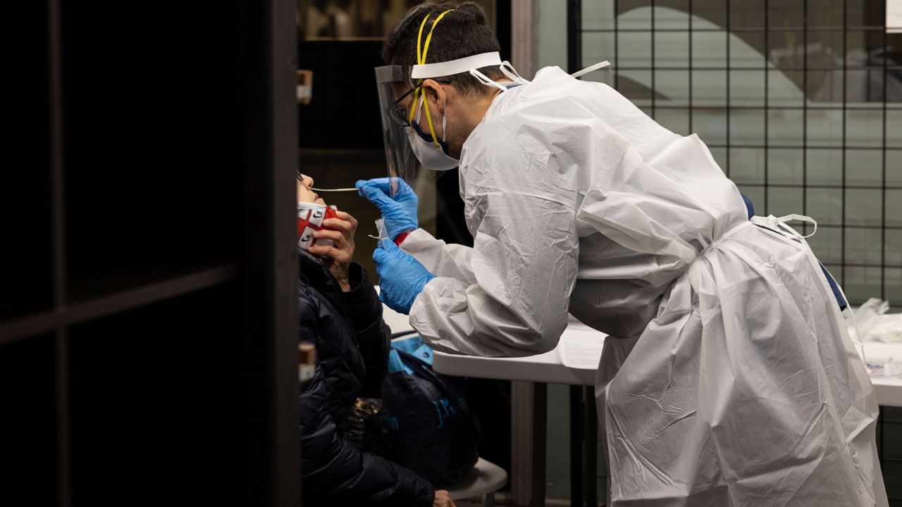A medical worker administers a COVID-19 test at a testing site in the Times Square subway station on Thursday, Dec. 30, 2021. (AP Photo/Yuki Iwamura)