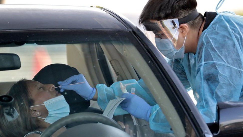 In this June 27, 2020, photo, people are tested in their in vehicles in Phoenix's western neighborhood of Maryvale in Phoenix for free COVID-19 tests organized by Equality Health Foundation, which focuses on care in underserved communities. Arizona's Republican governor shut down bars, movie theaters, gyms and water parks Monday, June 29, and leaders in several states ordered residents to wear masks in public in a dramatic course reversal amid an alarming resurgence of coronavirus cases nationwide. (AP Photo/Matt York)