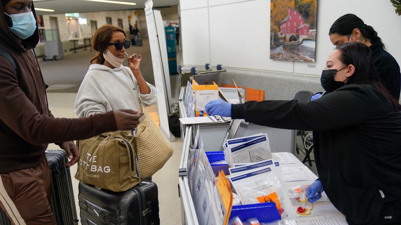 Passengers disembarking from international flights take anonymous COVID tests for study purposes at Newark Liberty International Airport in Newark, N.J., on Jan. 4. (AP Photo/Seth Wenig)