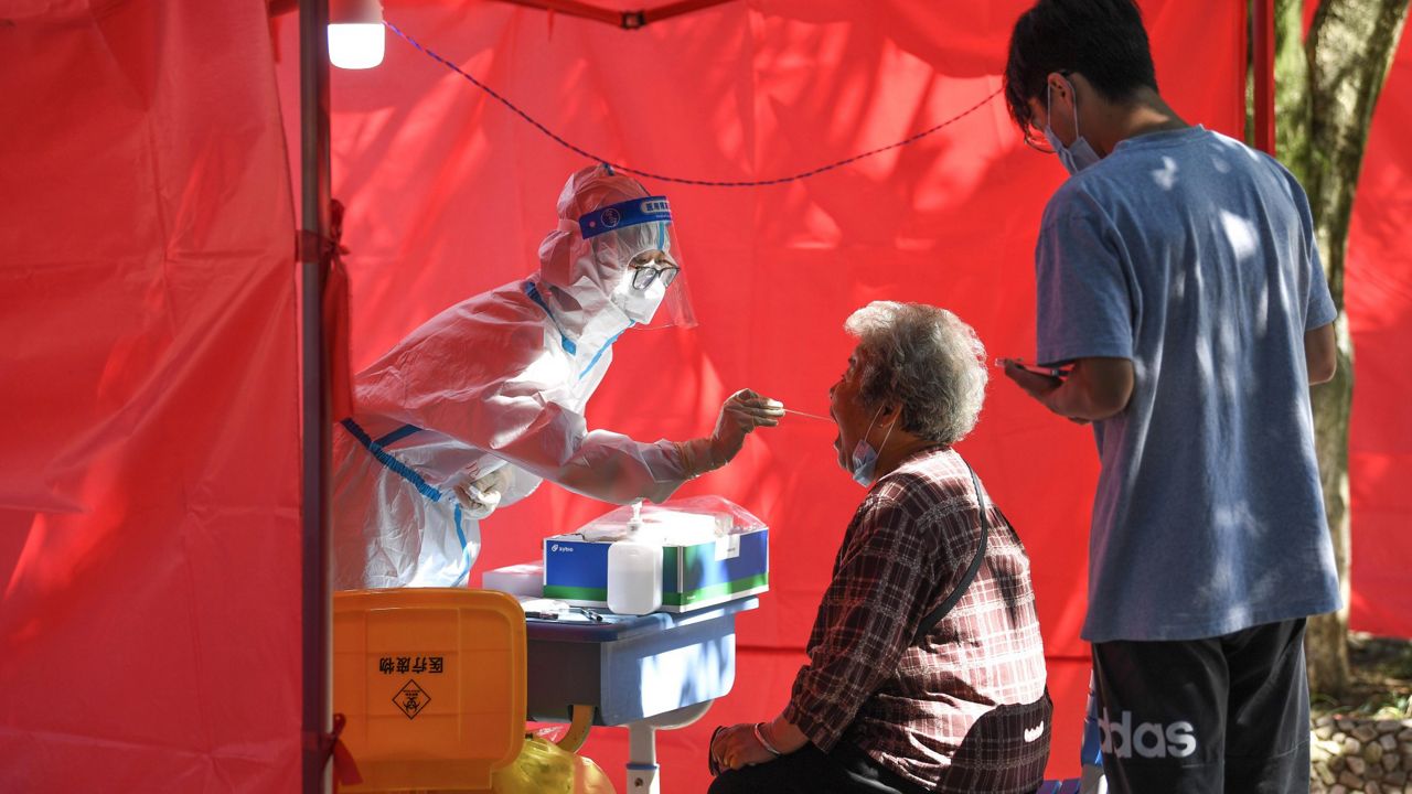 A medical worker takes a swab sample Sept. 5 from a resident at a community testing site for COVID-19 in the Yunyan District of Guiyang, in China's Guizhou Province. (Yang Wenbin/Xinhua via AP)