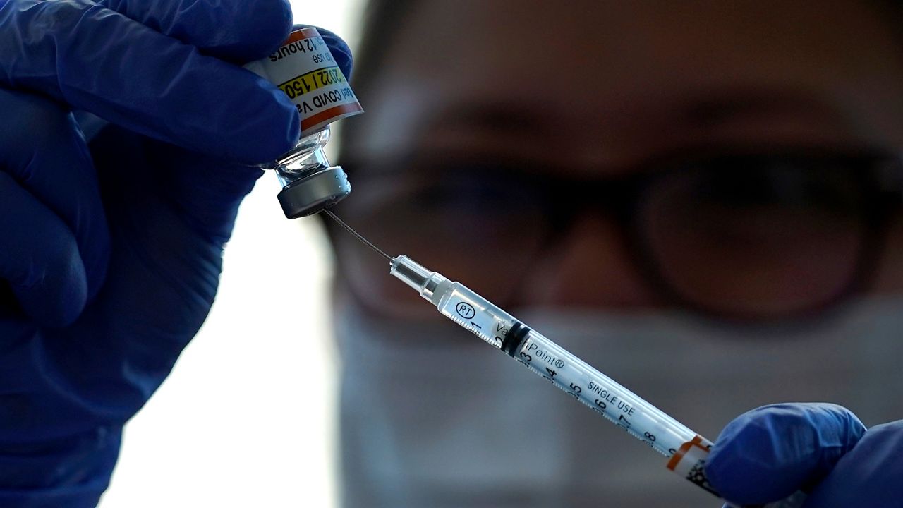 A health care worker prepares a syringe with a COVID-19 vaccine. (AP Photo, File)