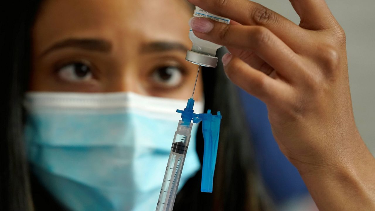 A health care worker prepares a syringe with a COVID-19 vaccine. (AP Photo, File)