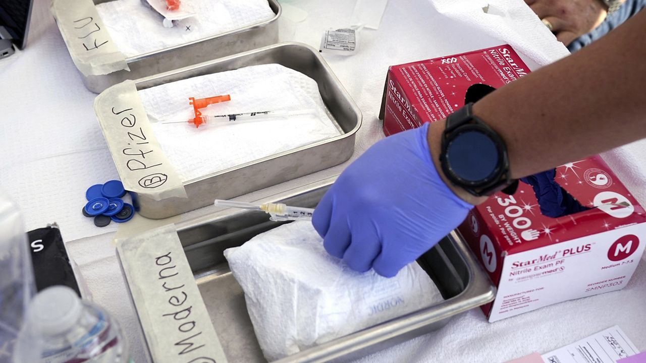 Syringes with vaccines are prepared at the L.A. Care and Blue Shield of California Promise Health Plans' Community Resource Center on Oct. 28, 2022, in Lynwood, Calif. (AP Photo/Mark J. Terrill, File)