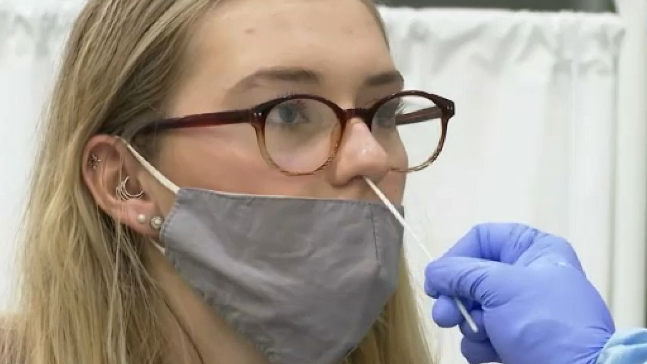 woman with mask getting swabbed