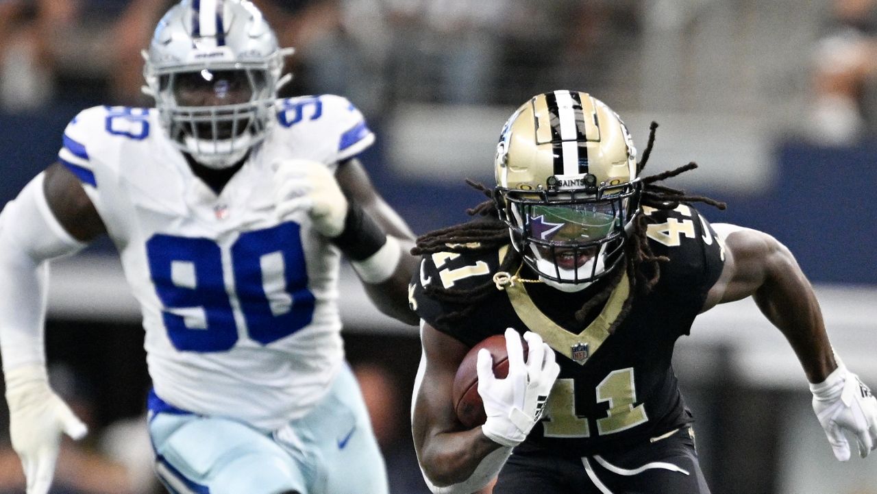 New Orleans Saints running back Alvin Kamara (41) breaks away with Dallas Cowboys defensive end DeMarcus Lawrence (90) in tow while running for a long touchdown during the first half of an NFL football game, Sunday, Sept. 15, 2024, in Arlington, Texas. (AP Photo/Tony Gutierrez)