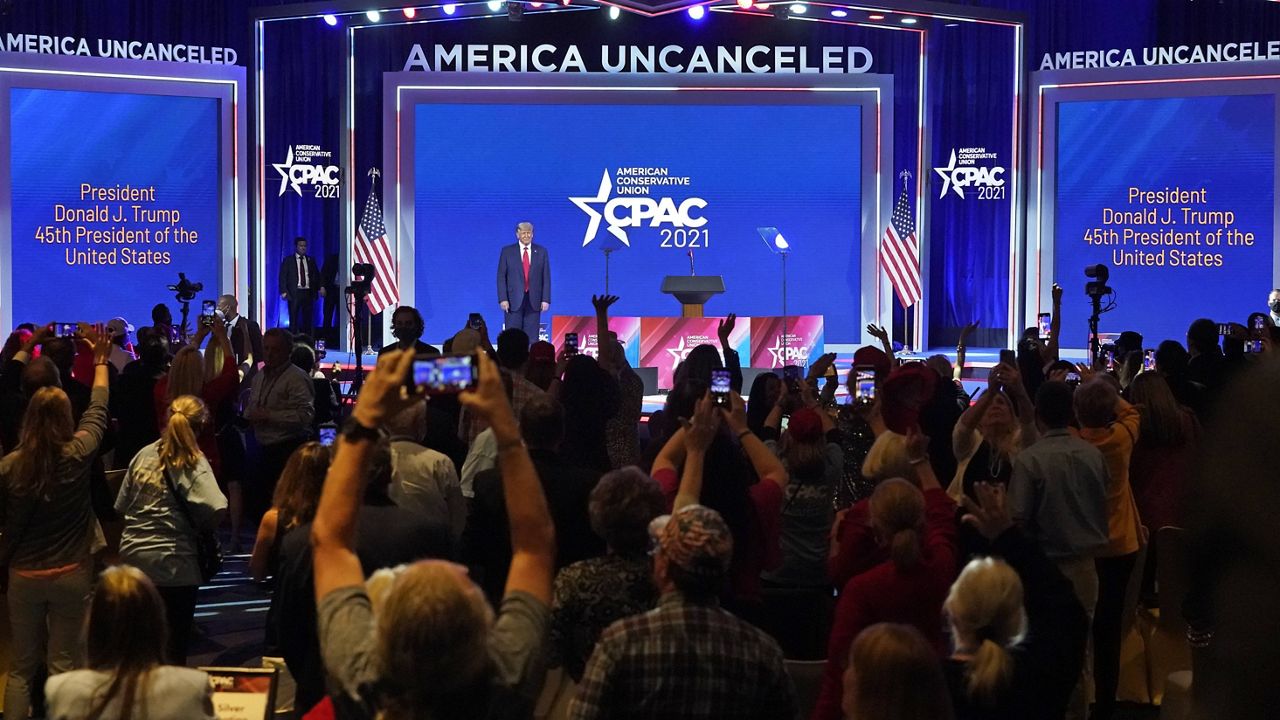 Supporters cheer and wave as former President Donald Trump is introduced at the Conservative Political Action Conference on Sunday in Orlando, Fla. (AP Photo/John Raoux)