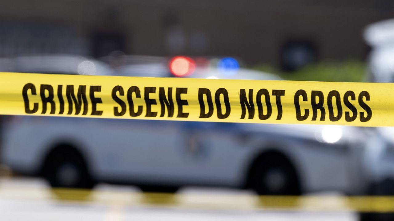 FILE - Yellow crime tape blocks off an area near a mall parking area where two Baltimore city police officers were shot and a suspect was killed as a U.S. Marshals' task force served a warrant, July 13, 2021, in Baltimore, Md. (AP Photo/Jose Luis Magana, File)