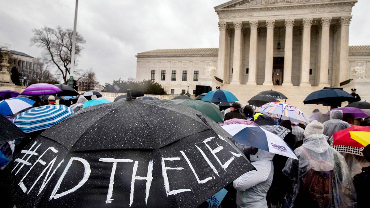 A pro-abortion rights supporter holds an umbrella that reads "#EndTheLies" during a rally outside the Supreme Court in Washington, Tuesday, March 20, 2018, as the Supreme Court hears arguments in a free speech fight over California's attempt to regulate anti-abortion crisis pregnancy centers. (AP Photo/Andrew Harnik)