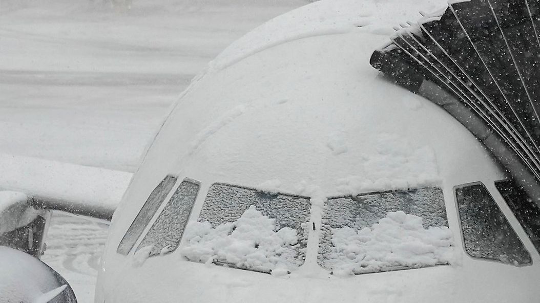 Snow covers the windows of a plane that sits at a gate at John F. Kennedy International Airport, Tuesday, Feb. 13, in New York. A winter storm hitting other states is complicating travel to and from Maine. (AP Photo/Frank Franklin II)