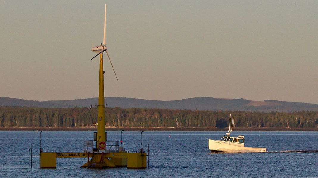 A lobster boat passes the country's first floating wind turbine off the coast of Castine, Maine, Sept. 20, 2013.  (AP Photo/Robert F. Bukaty)