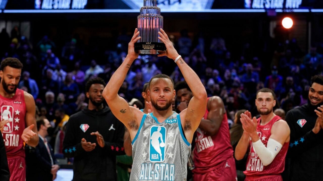 Golden State Warriors' Stephen Curry holds up the Kobe Bryant Trophy after being named the MVP of the NBA All-Star basketball game, Sunday, Feb. 20, 2022, in Cleveland. (AP Photo/Ron Schwane)