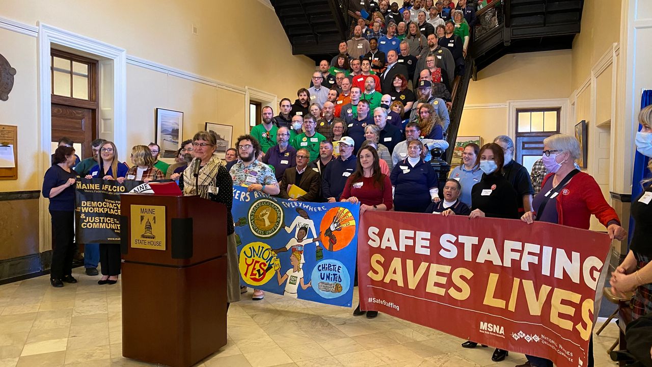 Cynthia Phinney, president of the Maine AFL-CIO, outlines union priorities Thursday with nearly 200 union workers standing behind her. (Susan Cover/Spectrum News)