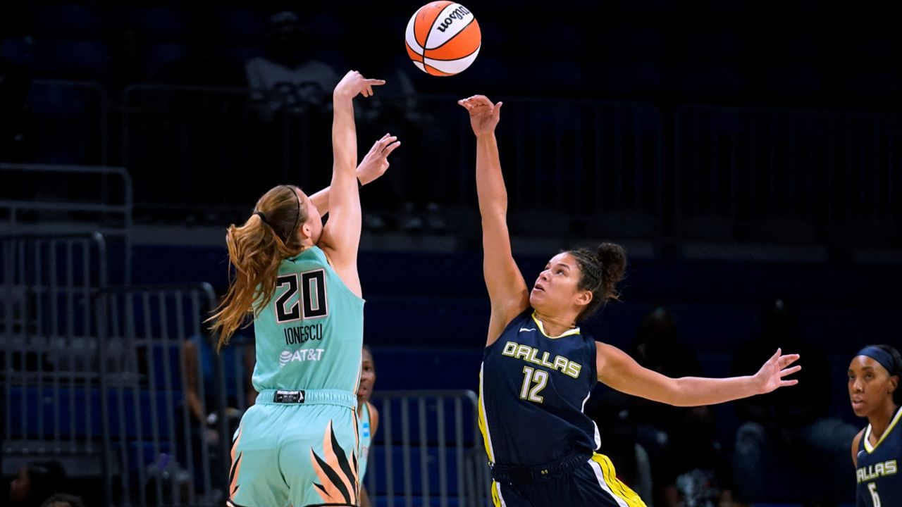 New York Liberty guard Sabrina Ionescu (20) has her shot blocked by Dallas Wings guard Veronica Burton (12) during the first half of a WNBA basketball game in Arlington, Texas, Wednesday, Aug. 10, 2022. (AP Photo/Tony Gutierrez)