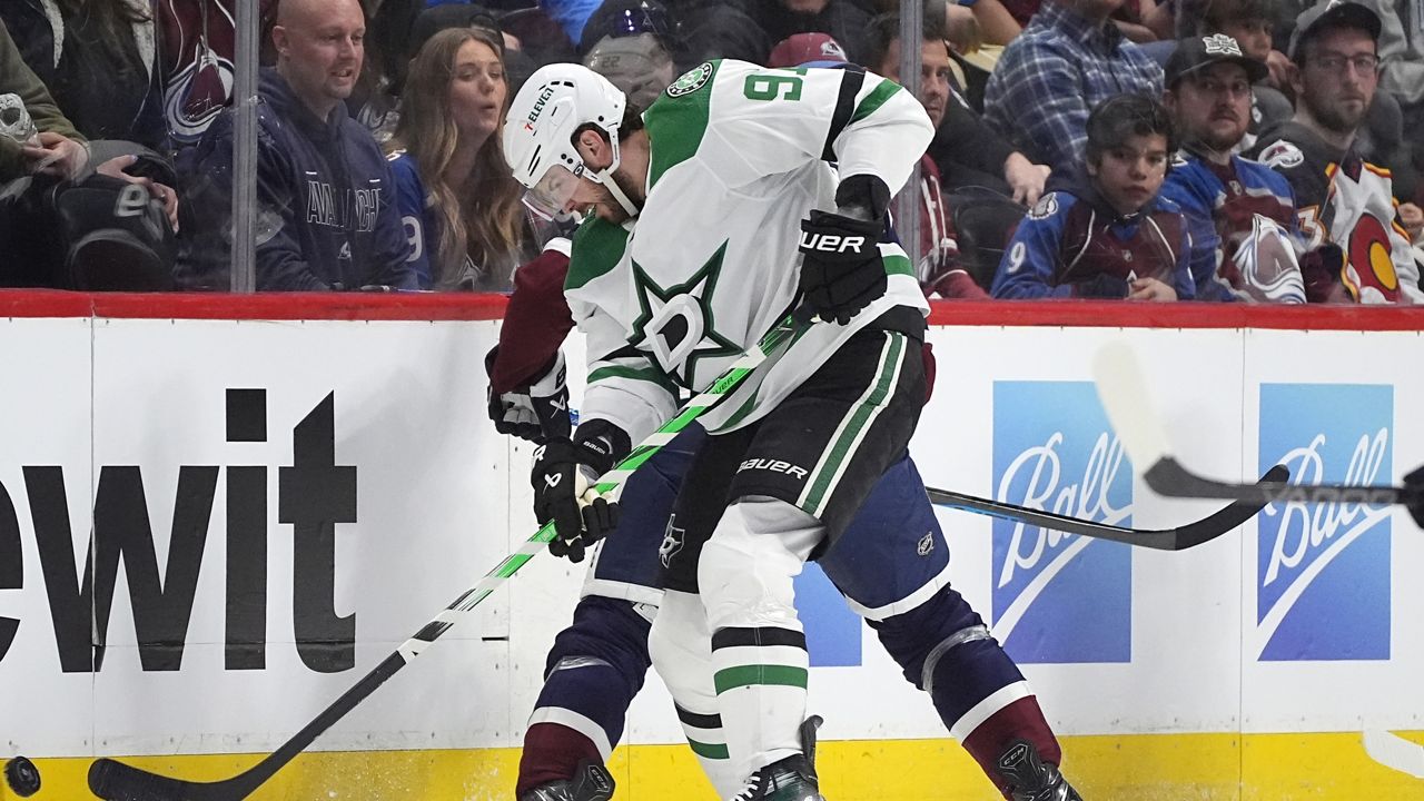 Dallas Stars center Tyler Seguin, front, clears the puck while checking Colorado Avalanche left wing Zach Parise in the second period of an NHL hockey game Sunday, April 7, 2024, in Denver. (AP Photo/David Zalubowski)