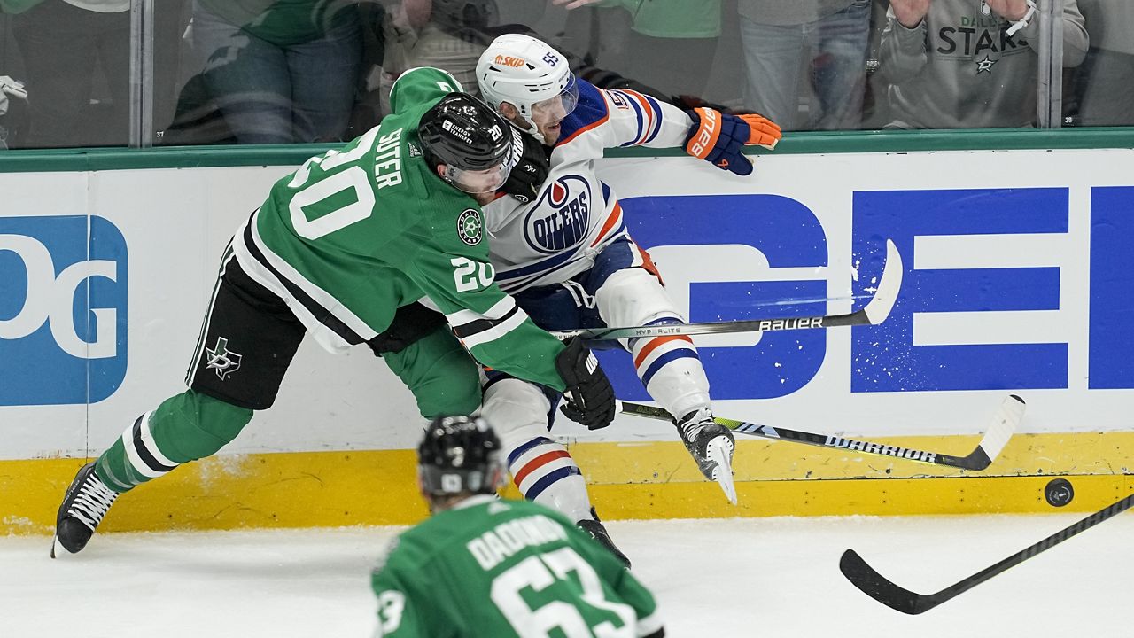 Dallas Stars defenseman Ryan Suter (20) collides with Edmonton Oilers left wing Dylan Holloway (55) as Stars' right wing Evgenii Dadonov (63) looks on during overtime in Game 1 of the NHL hockey Western Conference Stanley Cup playoff finals, Thursday, May 23, 2024, in Dallas. (AP Photo/Tony Gutierrez)
