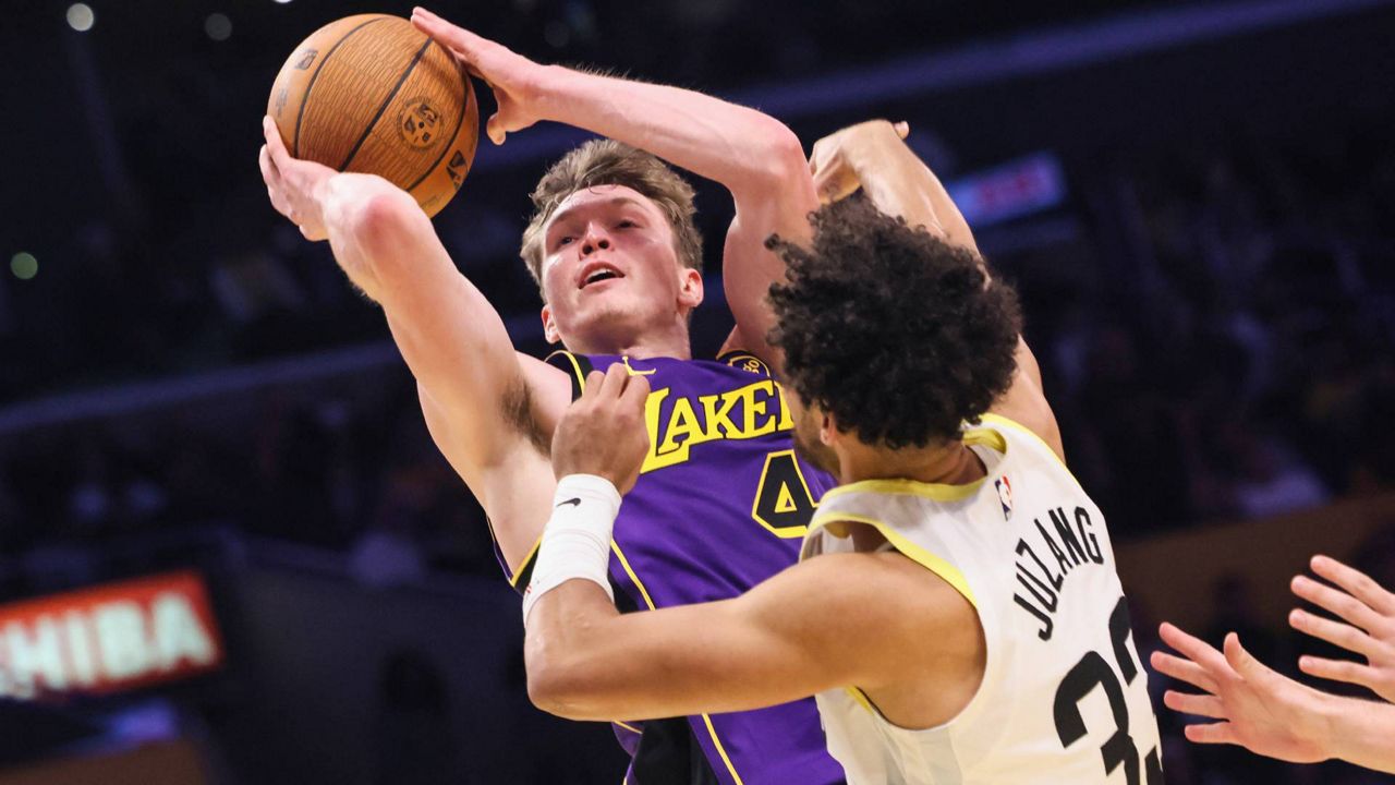 Los Angeles Lakers guard Dalton Knecht, left, attempts to score against Utah Jazz guard Johnny Juzang during the second half of an Emirates NBA Cup basketball game, Tuesday in LA. (AP Photo/Etienne Laurent)