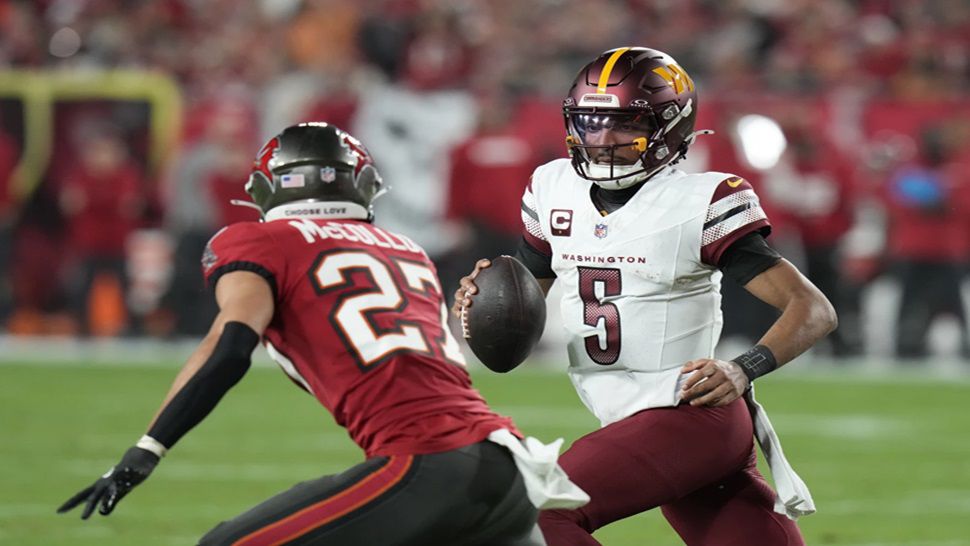 Washington Commanders quarterback Jayden Daniels (5) runs against Tampa Bay Buccaneers cornerback Zyon McCollum (27) during the first half of an NFL wild-card playoff football game in Tampa, Fla., Sunday, Jan. 12, 2025. (AP Photo/Chris O'Meara)