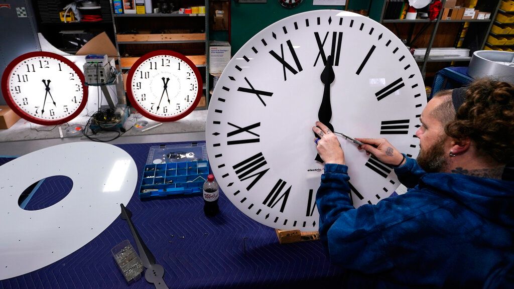 Ian Roders fastens hands to a clock. 