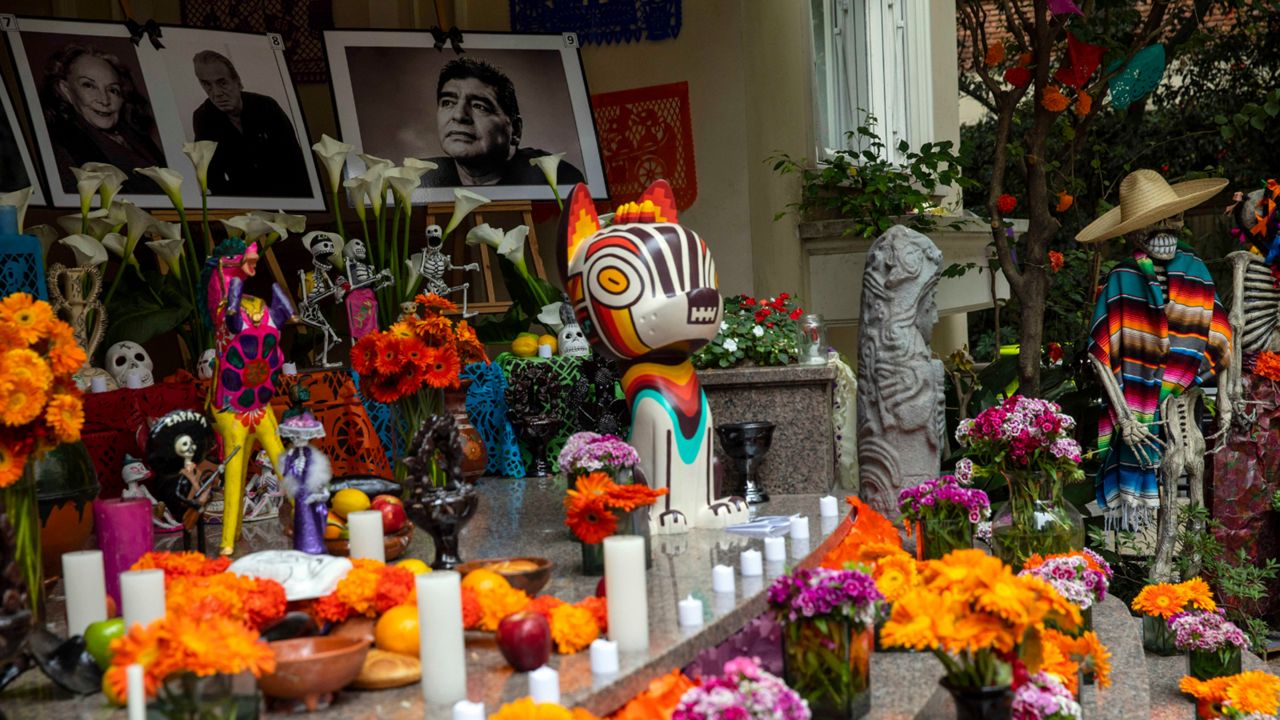 Portraits, from left, of Mexican actress Isela Vega, Mexican composer and singer Oscar Chavez, and Argentine soccer star Diego Maradona, are displayed on an altar at the entrance to the Mexican embassy in Buenos Aires, Argentina, during Day of the Dead celebrations, Sunday, Oct. 31, 2021. (AP Photo/Rodrigo Abd)