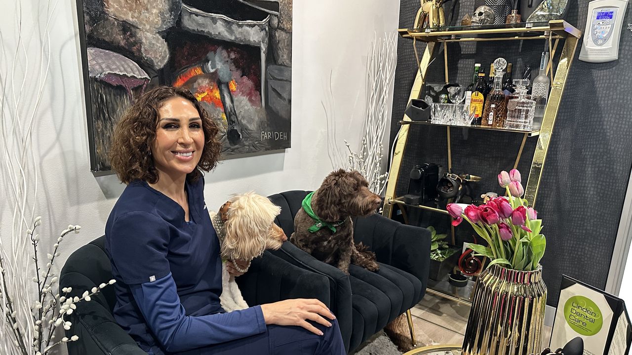 Dr. Mojdeh Shayestehfar sits in her home-like lobby area with Softie and Parker. (Spectrum News/Jo Kwon)