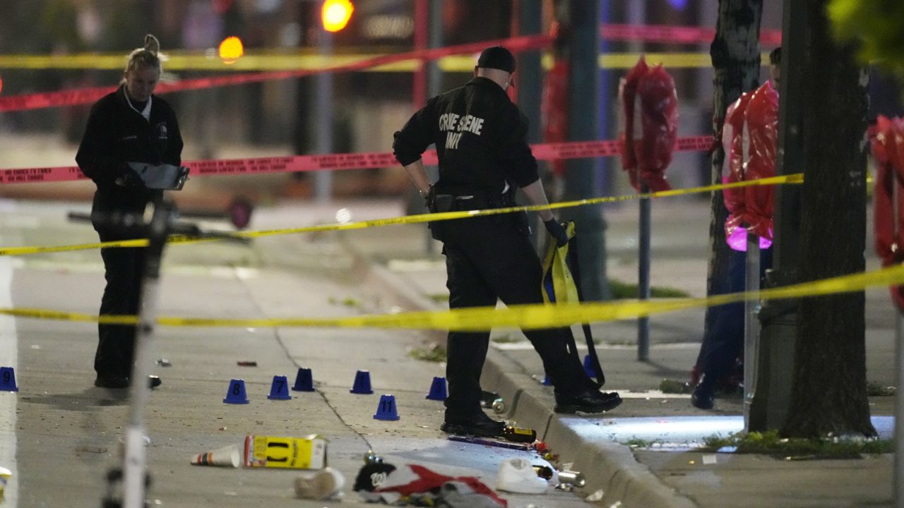 Denver Police Department investigators work the scene of a mass shooting along Market Street during a celebration after the Denver Nuggets won the team's first NBA championship early Tuesday. (AP Photo/David Zalubowski)