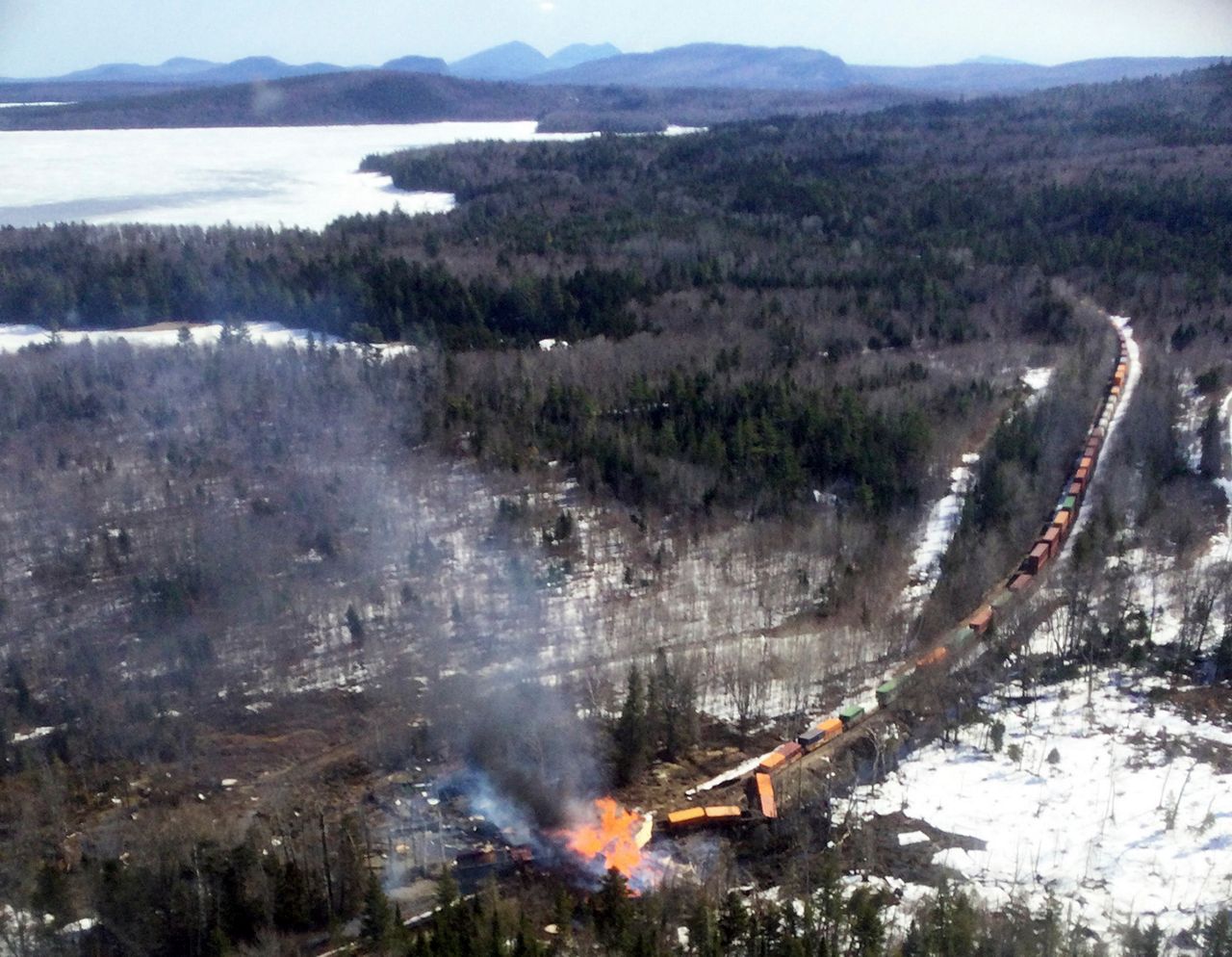 Several locomotives and rail cars burn after a freight train derailed, Saturday, April 15, in Sandwich Academy Grant Township, near Rockwood, Maine. Three workers were treated and released from a hospital, and Canadian Pacific Railway will be leading the cleanup and track repair, according to officials. (Maine Forest Service via AP)