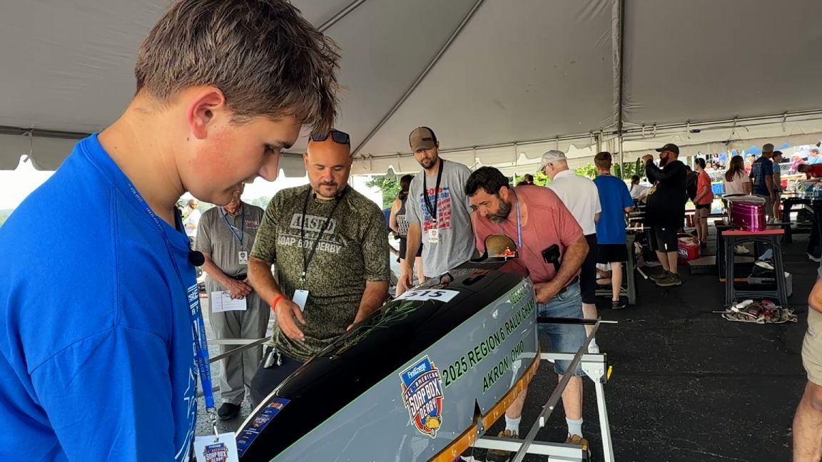 Keegan Altomare works on his derby car with his dad Kevin Altomare and other helpers under the assembly tent at Derby Downs. 