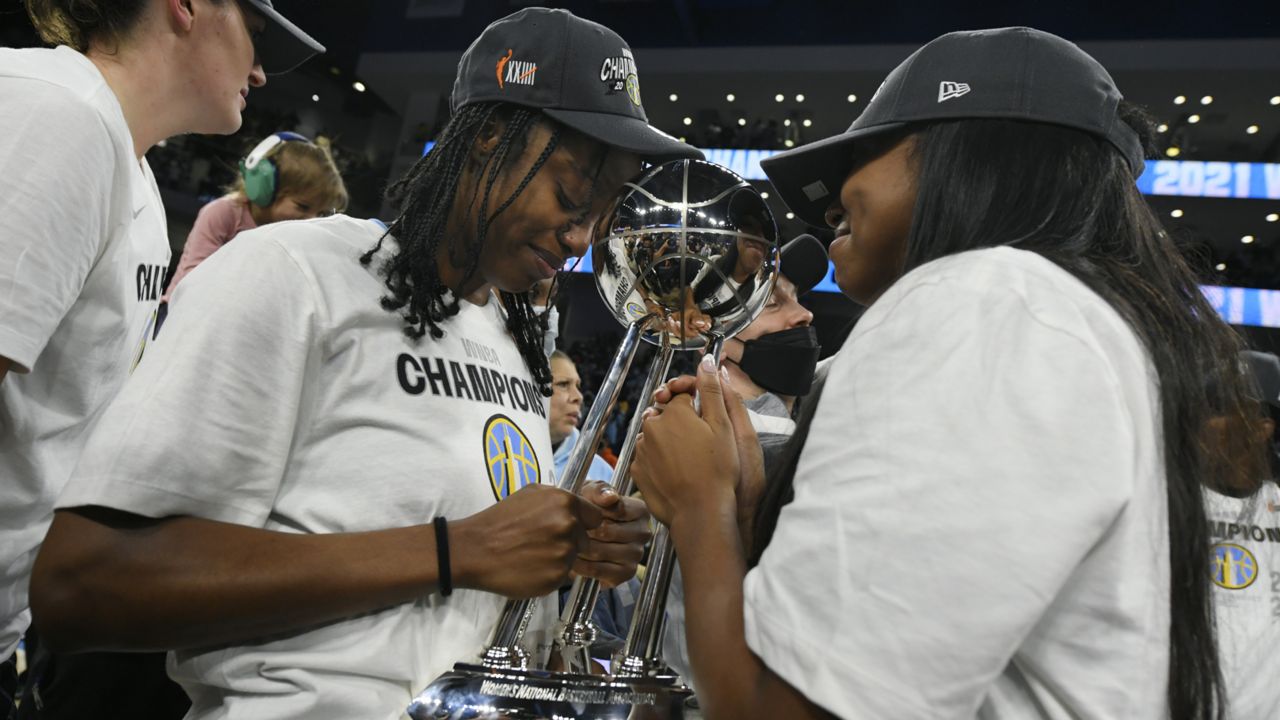 Chicago Sky's Diamond DeShields, left, and Lexie Brown, right, celebrate with the trophy after defeating the Phoenix Mercury 80-74 in Game 4 of the WNBA Finals to become the 2021 WNBA champions, Sunday, Oct. 17, 2021, in Chicago. (AP Photo/Paul Beaty)