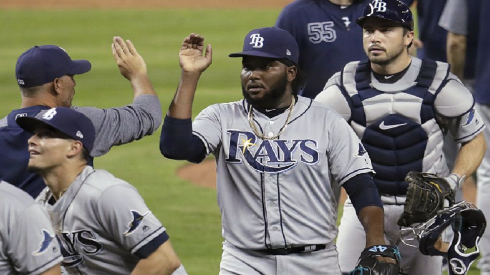 Tampa Bay Rays manager Kevin Cash, left, high-fives relief pitcher Diego Castillo, center, after the Rays defeated the Miami Marlins 1-0 in a baseball game Wednesday, May 15, 2019, in Miami. At right is Rays catcher Travis d'Arnaud. (AP Photo/Lynne Sladky)