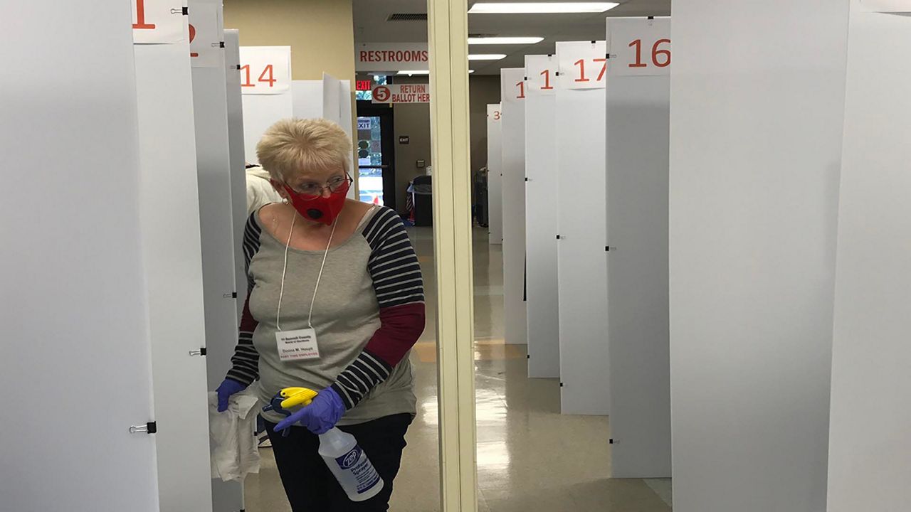 Photo of a woman sanitizing booths