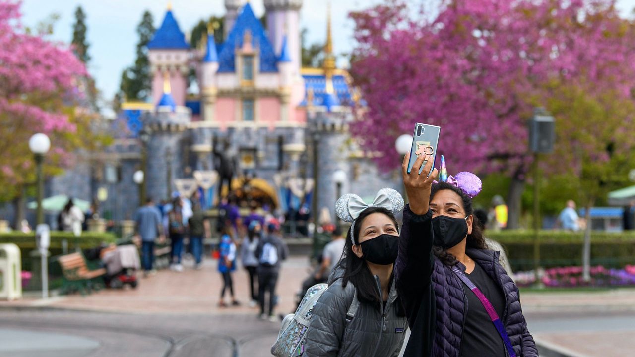 Visitors take a selfie in front of the Sleeping Beauty Castle at Disneyland (Courtesy Disneyland Resort)
