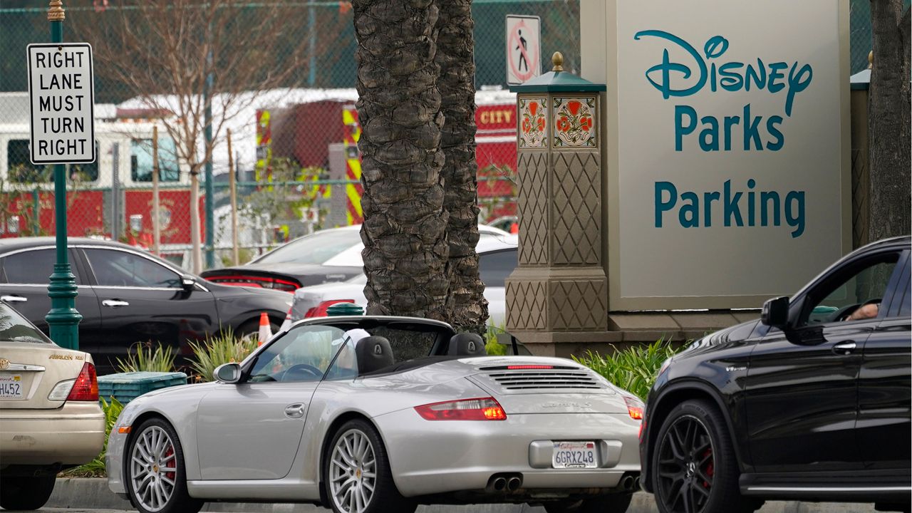 In this Jan. 13, 2021, file photo, vehicles queue up outside the Disneyland Resort parking lot for a COVID-19 vaccine in Anaheim, Calif. (AP Photo/Damian Dovarganes, File)
