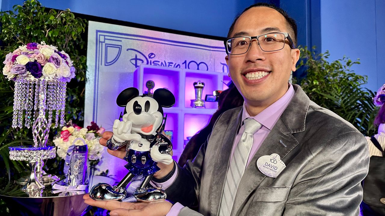 David Nguyen, a member of Disneyland's food and beverage team, holds up a Mickey Mouse sipper. (Spectrum News/Joseph Pimentel)