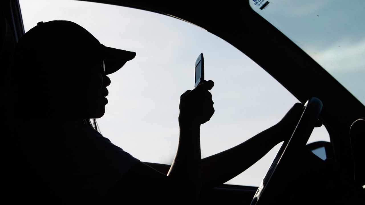 A driver uses a cell phone in Yarmouth, Maine, Sept. 8, 2009. 